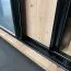1,1 Meter breiter Schiebetürenschrank Mina in Weiß, viel Stauraum, Vorderseite aus Laminat Platten, Anti Staubbürsten, robust, Schwarze Lamellen Optik